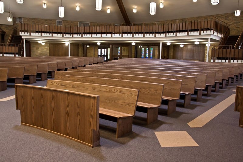 dark stained row of curved pews