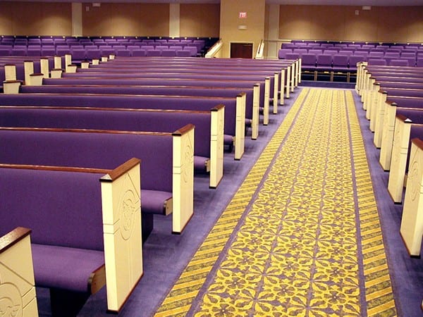Curved pews with purple upholstery line the sanctuary of the North Cleveland Church of God in Cleveland, TN.