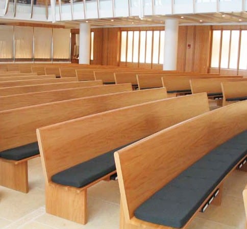 close up of curved pews with padded seats