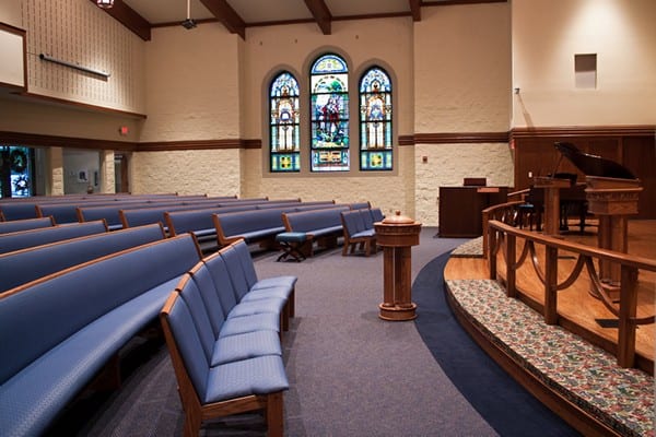 The interior of a church with both chairs and pews.
