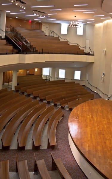 rows of curved pews with 2nd floor