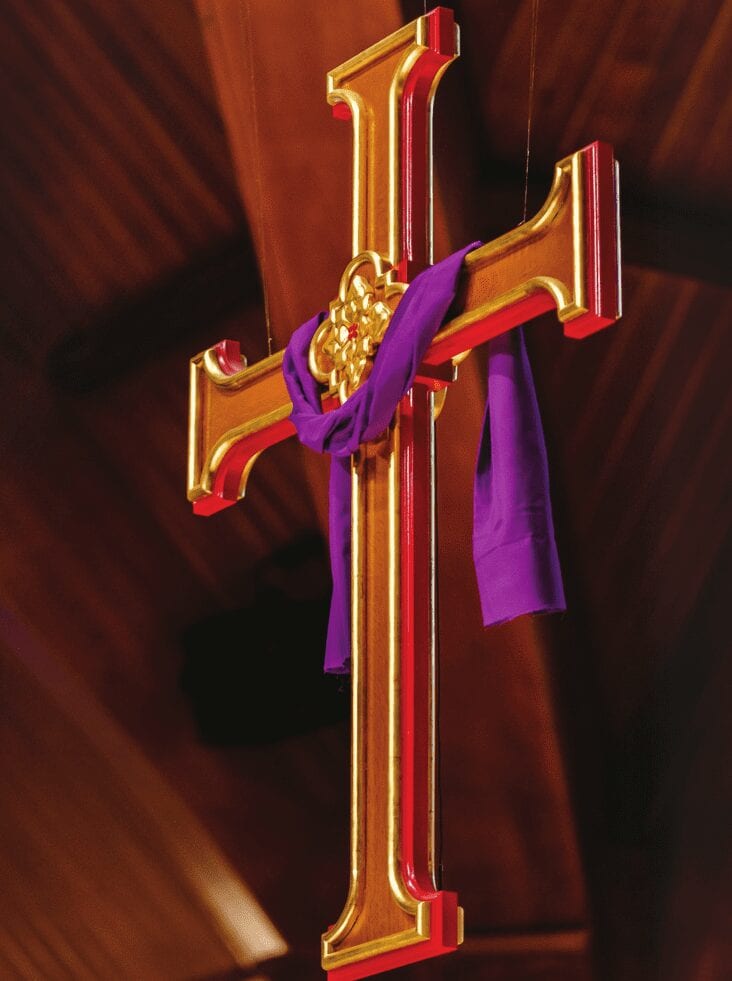 gold inlay on cross with purple drape