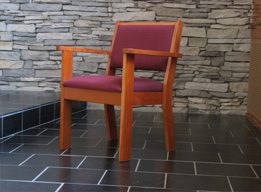 a wooden church chair with burgundy padding